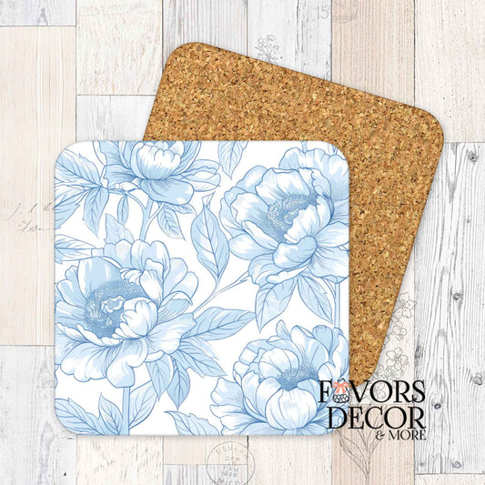 Square blue floral cork coaster with vintage toile pattern and cork backing, styled on whitewashed wood.
