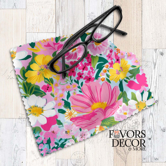 Colorful floral lens cloth with vibrant pink, yellow, and white flowers on a light blue background, styled with black eyeglasses.