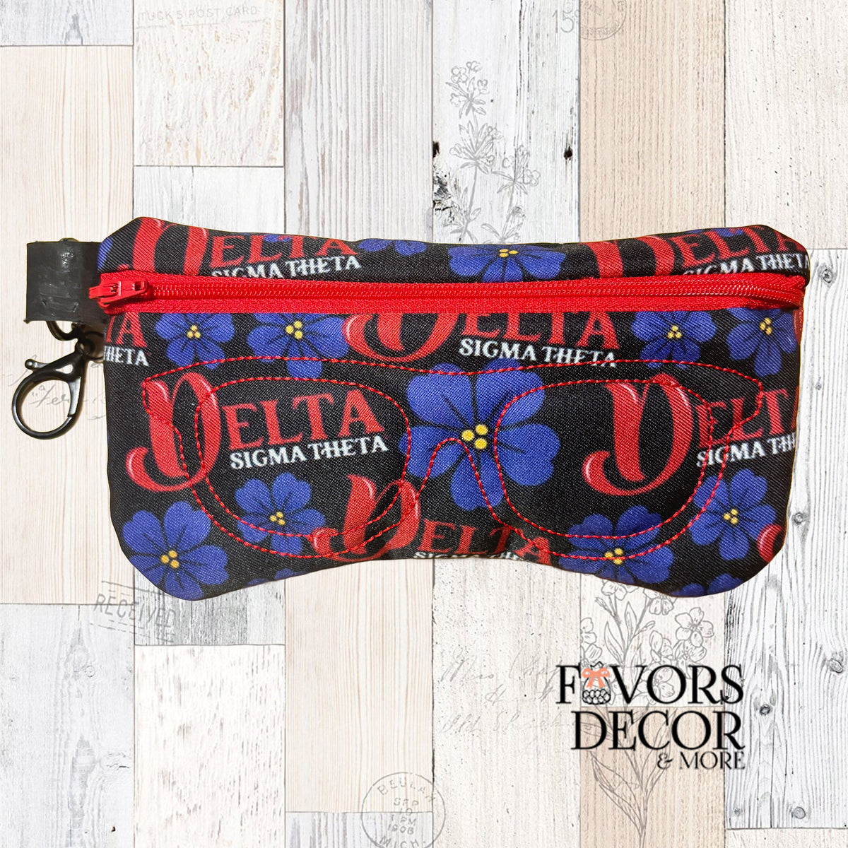 Delta Sigma Theta eyeglass pouch with red zipper featuring purple violets and DST logo on a black background.