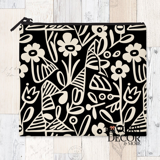 A reusable sandwich pouch featuring a black and white abstract botanical or leaf pattern on the exterior. The pouch has a white zipper closure and is made with a food-safe PUL fabric lining.