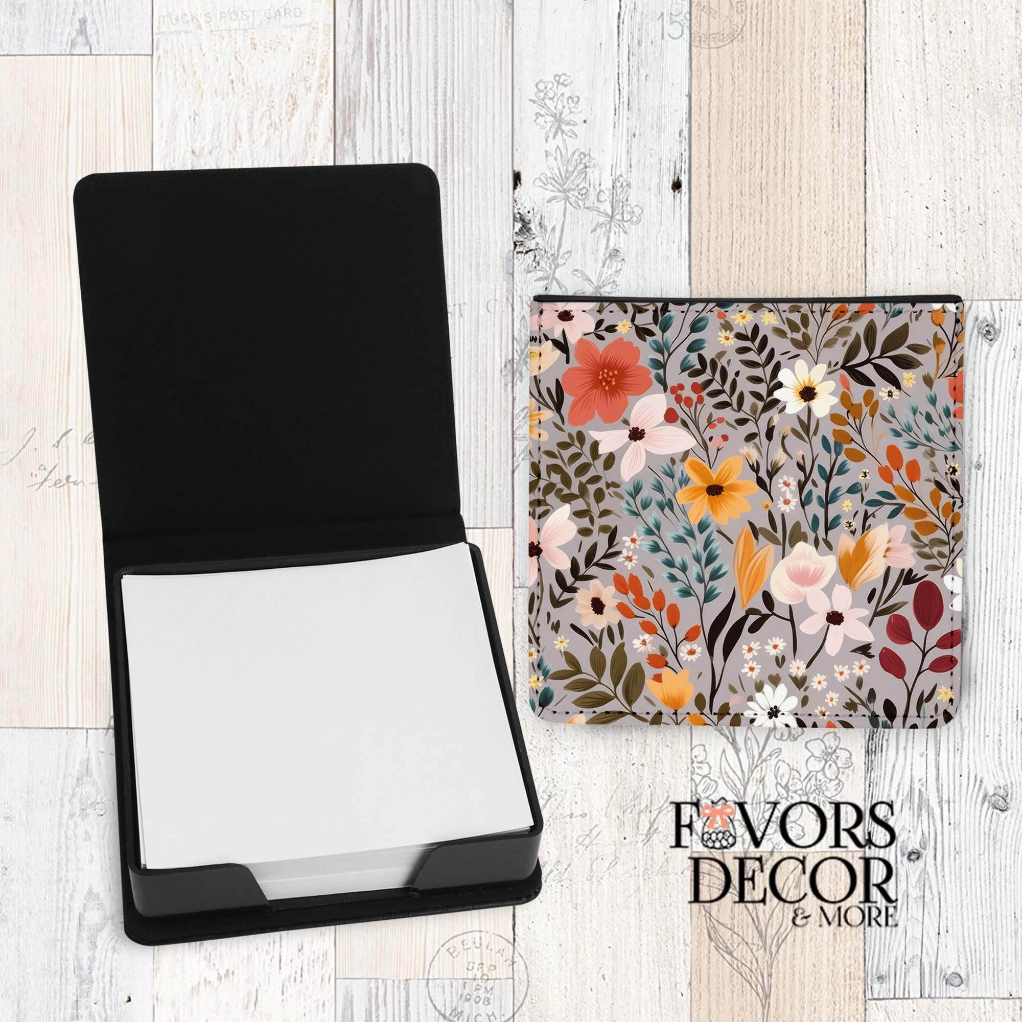 Floral-patterned pouch with a black rectangular item on a wooden surface, branded 'Favors & Decor'.