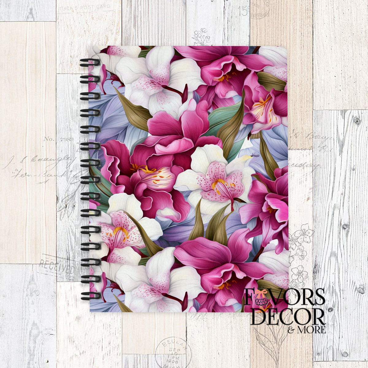 Spiral notebook with vibrant magenta and cream orchid floral design on the cover, set on a rustic whitewashed wood background with “Favors Decor &amp; More” logo