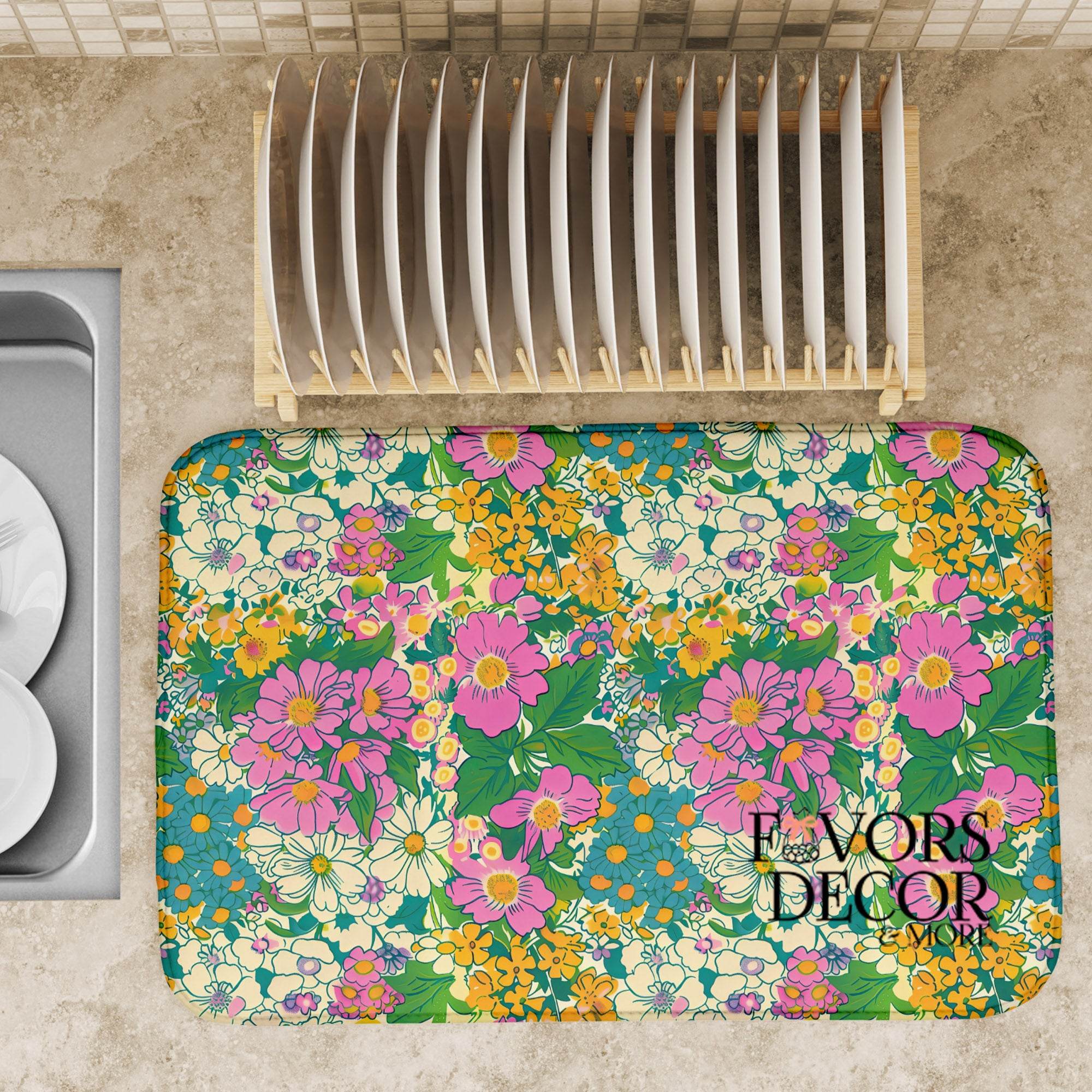 Dish drying mat with colorful vintage-inspired floral design in pink, yellow, teal, and cream, styled on a kitchen counter with a dish rack.