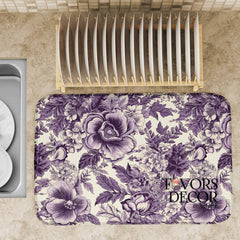 Dish drying mat with detailed purple floral design on a kitchen counter, styled with plates and a dish rack