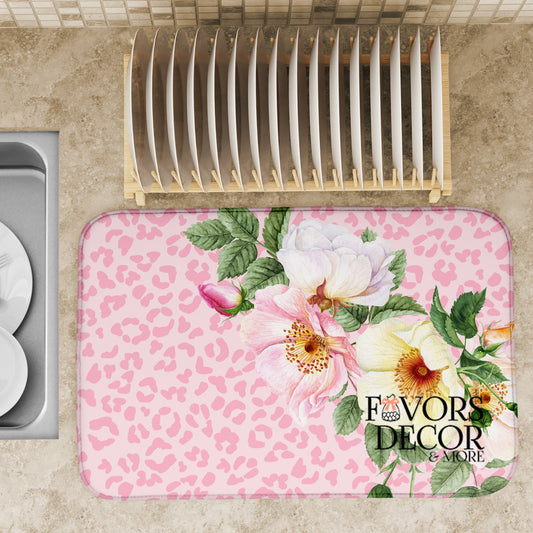 Dish drying mat with pink and yellow florals on a light pink leopard print background, shown beside a dish rack on a kitchen counter, branded Favors Decor &amp; More.
