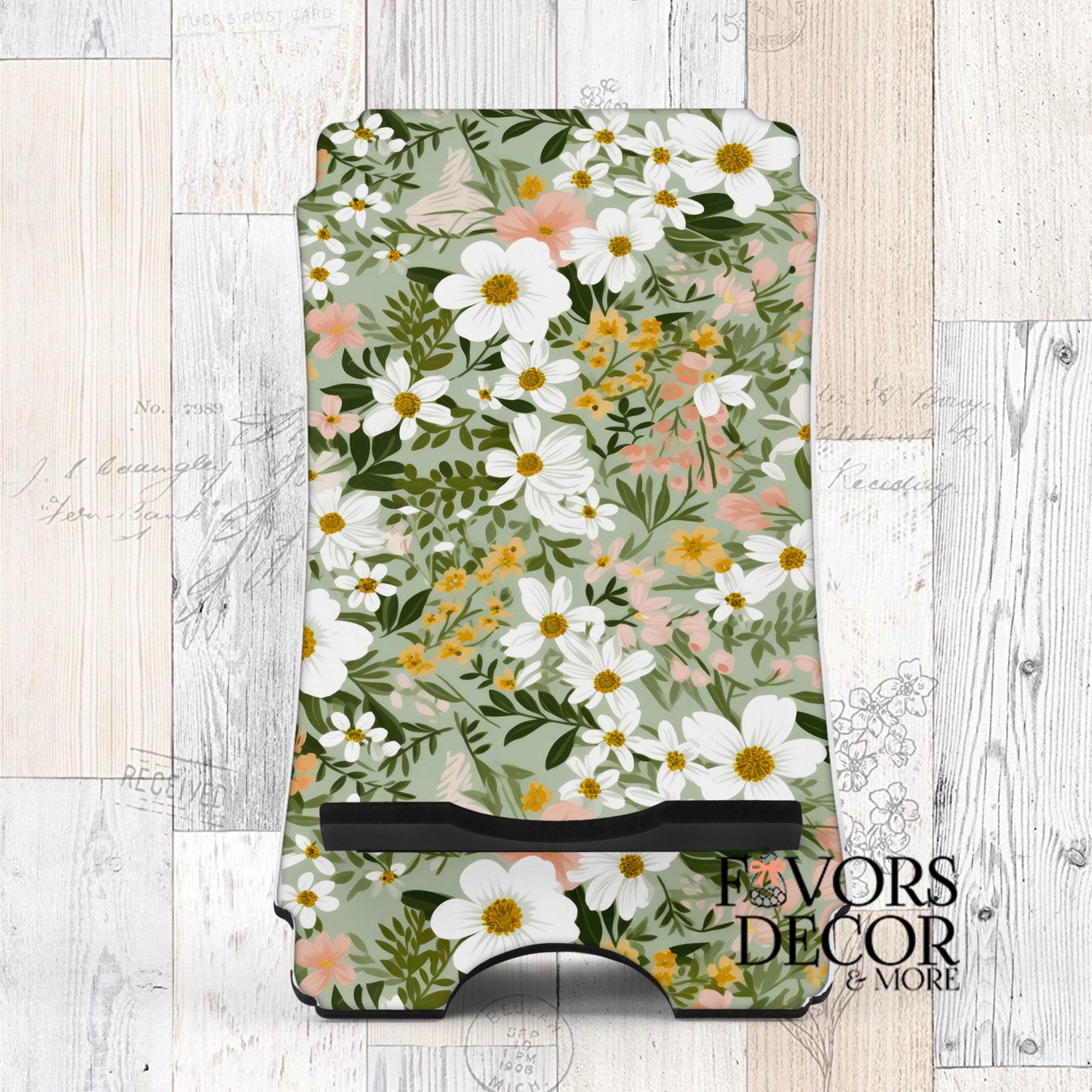 Phone stand with Soft Meadow design featuring white, yellow, and peach flowers on a sage green background.