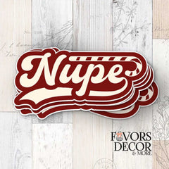 Stack of crimson and cream "Nupe" stickers featuring a Kappa cane design, displayed on a light wood background with Favors Decor & More logo.