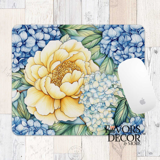 Mouse pad featuring a large yellow peony and clusters of blue hydrangeas with green leaves, styled with an Apple mouse and Favors Decor &amp; More logo.